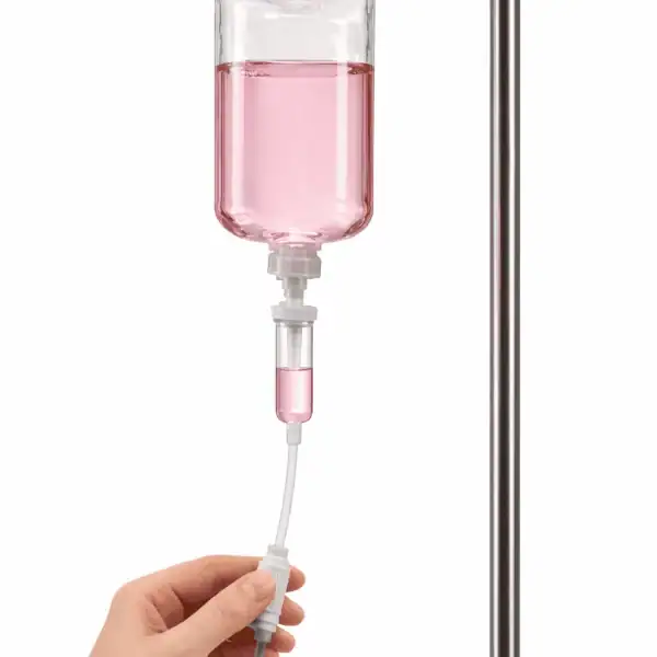 Infusionsflasche mit rosa Flüssigkeit, die an einem Infusionsständer hängt, für Vitalstofftherapie.